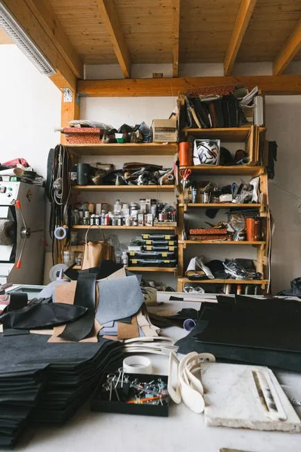 Atelier de maroquinerie à Bergame, pièces de cuir découpées et étagères
