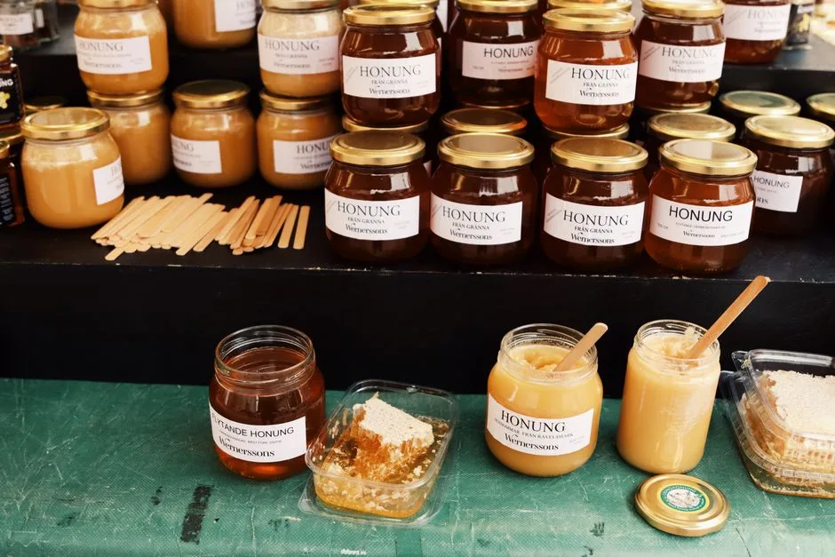 Pots de miel assortis présentés sur un stand de marché à Bergame