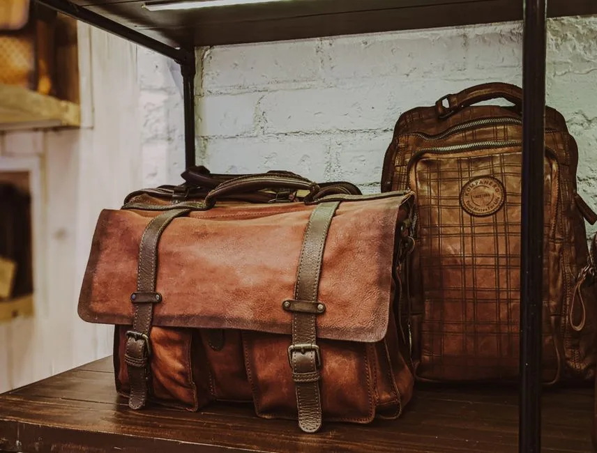 Sacoche et sac à dos en cuir artisanal exposés dans une boutique de Bergame