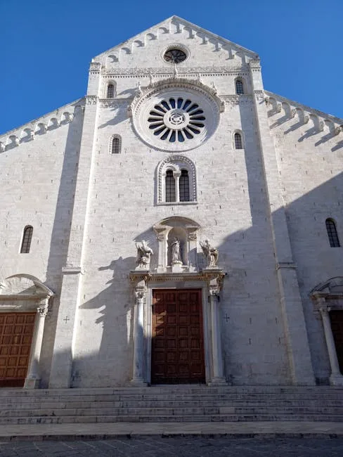 Façade en pierre blanche d'une cathédrale romano-gothique au ciel bleu