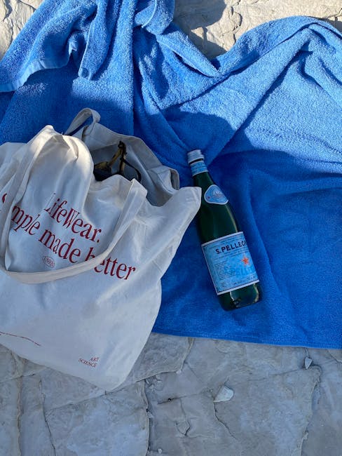 Beach bag essentials water bottle hat towel