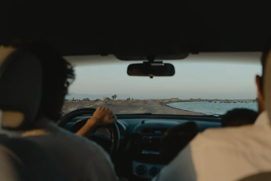 Vue depuis l'habitacle, conducteur au volant sur une route côtière vers Trieste