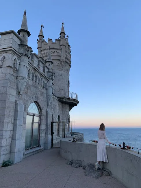 Vrouw op balkon van Miramare kijkt uit over de Adriatische Zee bij zonsondergang