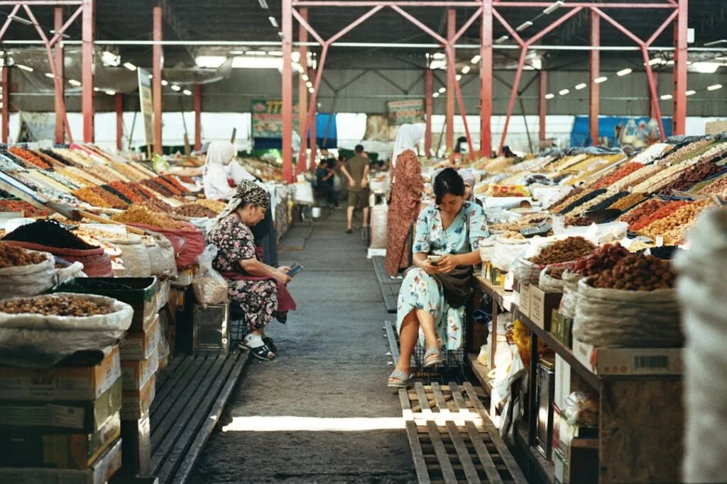 Allées de marché couvert bordées de sacs de fruits secs et vendeuses