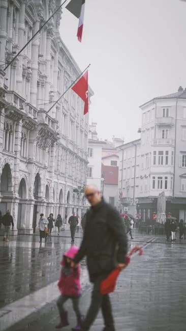 personnes floues marchant sous la pluie à la Piazza Unità, Trieste