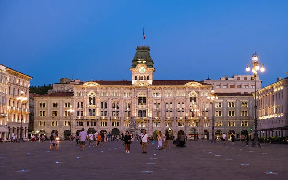Place Unità d'Italia à Trieste au crépuscule, promeneurs et lampadaires