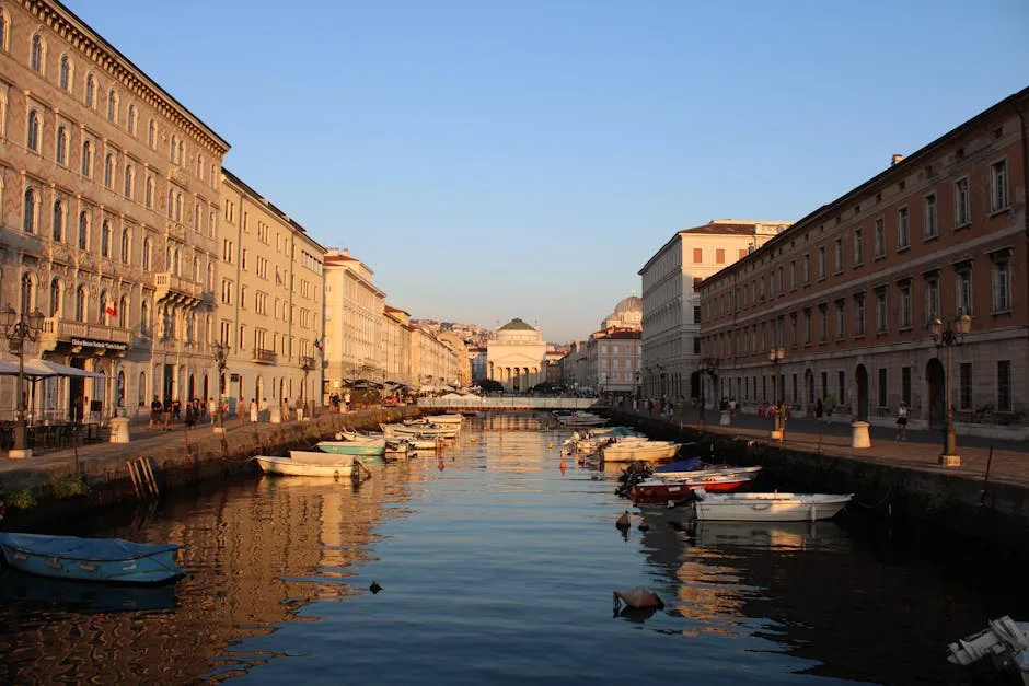 Canal de Trieste au crépuscule, barques amarrées le long des quais.