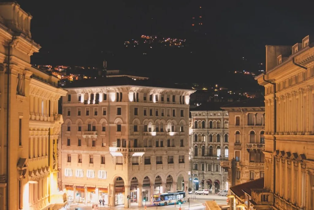 Perspective nocturne des rues de Trieste, bâtiments éclairés et bus
