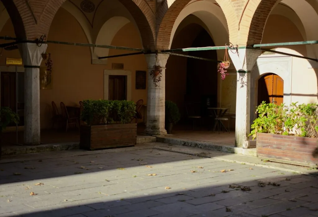 Cloître d'Aquileia aux arcades ombragées et jardinières