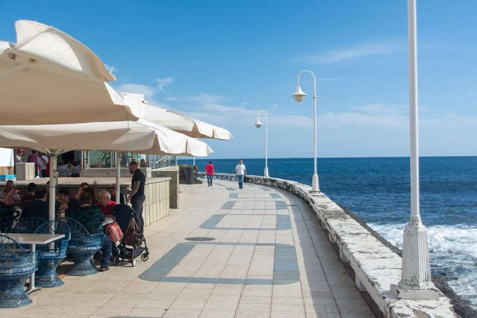 Promenade maritime de Trieste avec terrasse de café et lampadaires blancs