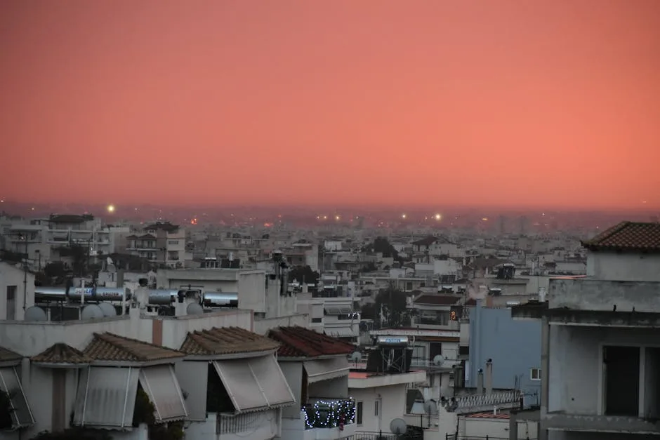 Toits de Trieste au crépuscule, ciel orangé à l'horizon