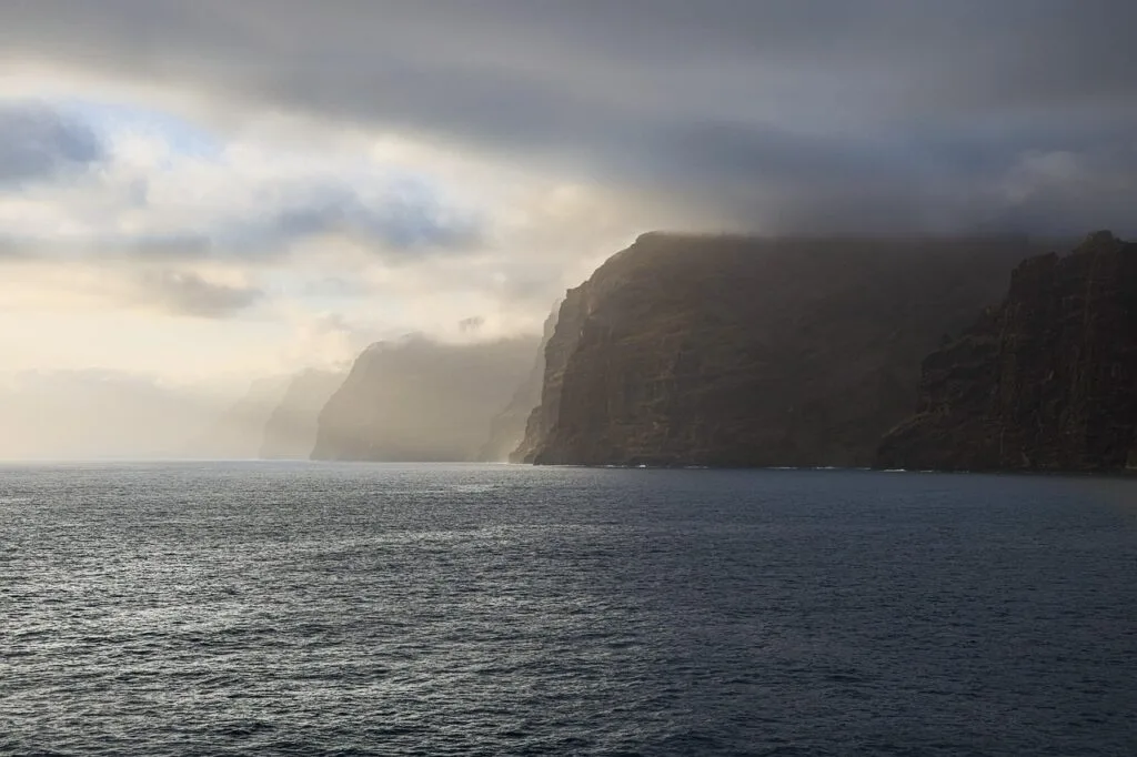 Falaises rocheuses dominant une mer brumeuse sous un ciel lourd