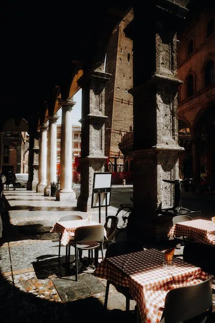 Sunlit colonnade and checkered cafe tables under Trieste arcades