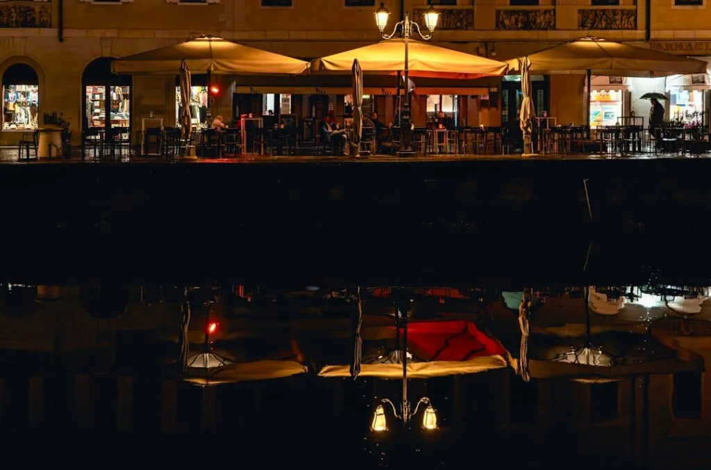 Terrasse de café sur les quais de Trieste, réflexion chaude dans l'eau