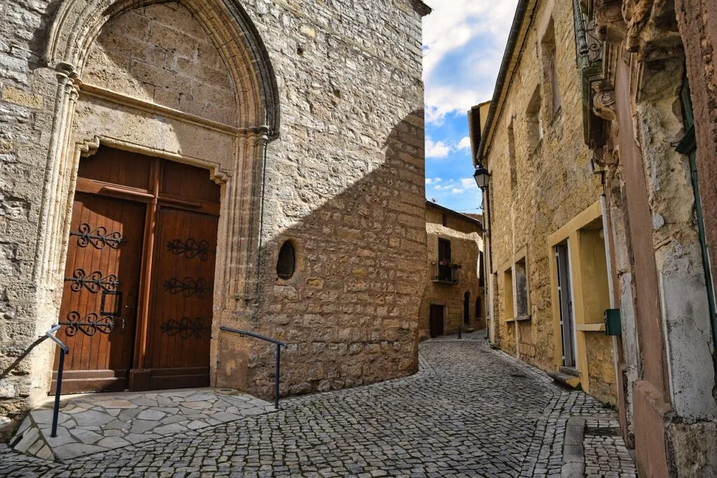 Ruelle pavée en pierre avec vieille porte d'église à Trieste