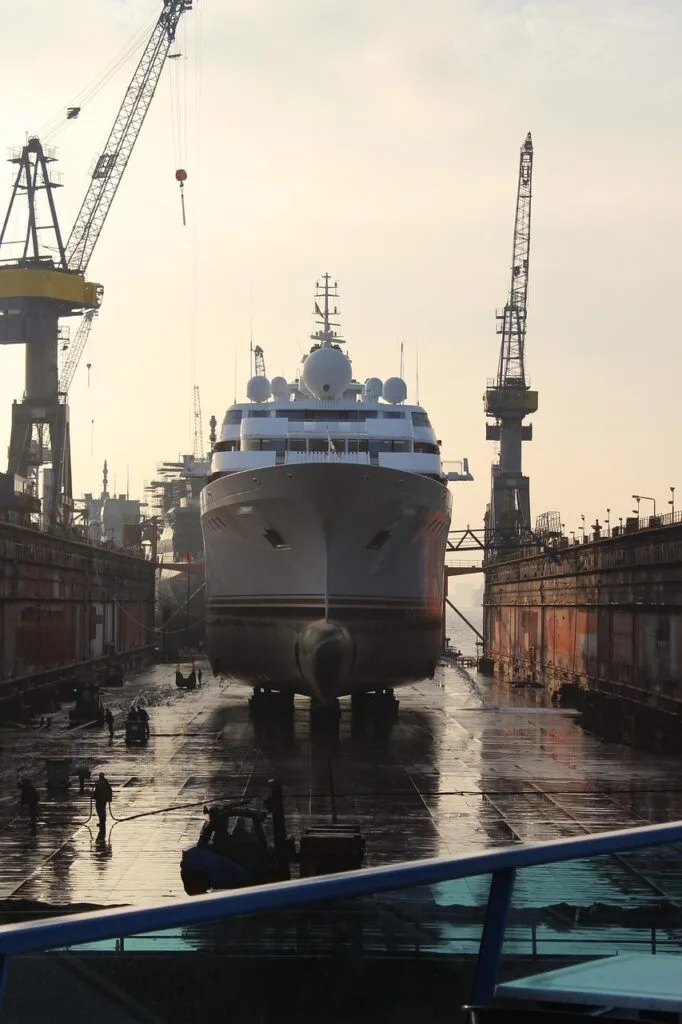 Proue d'un yacht calée dans le dock entouré de grues à Trieste