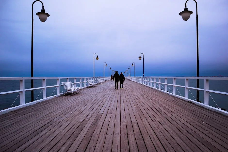 Wooden pier in Trieste stretching into calm sea under lamps