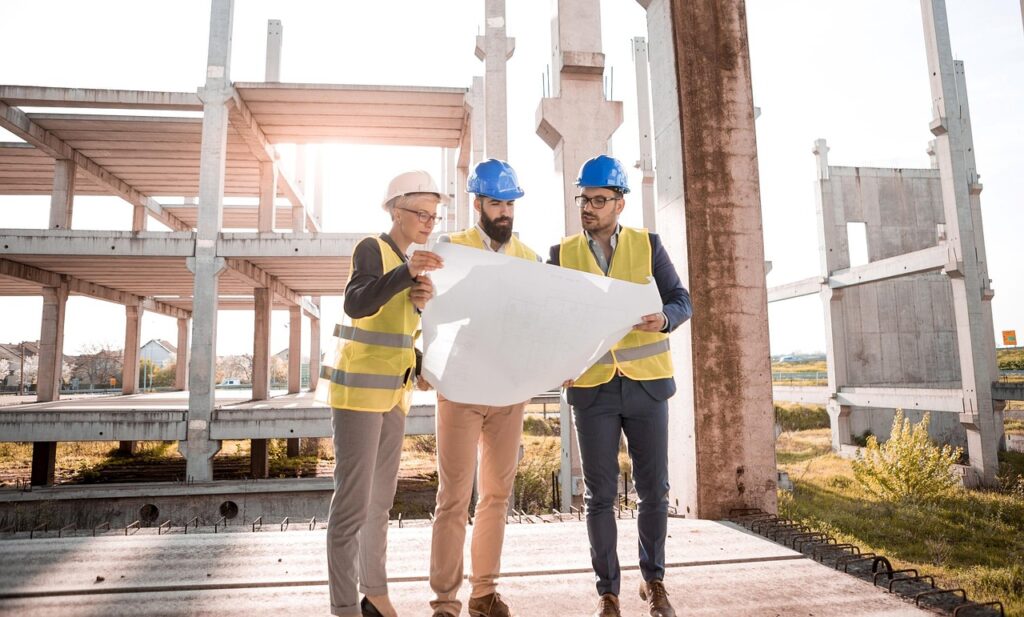 Visitors on a guided shipyard tour wearing helmets and vests