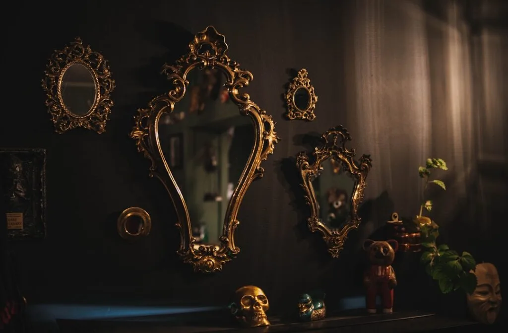 Miroirs dorés anciens alignés sur un mur sombre rempli d'objets