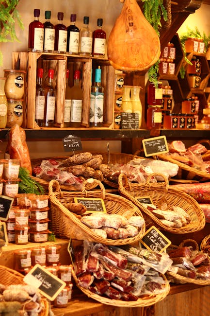 Étal charcuterie avec jambons suspendus et bocaux dans une épicerie.