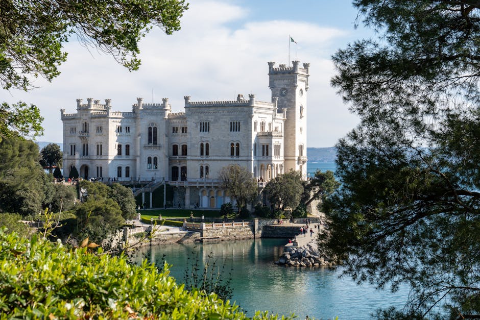 Château Miramare blanc sur la côte, encadré d'arbres à Trieste