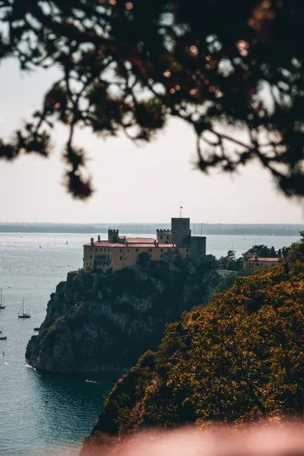 Schloss Miramare in Triest auf einer Klippe, Segelboote im Meer.