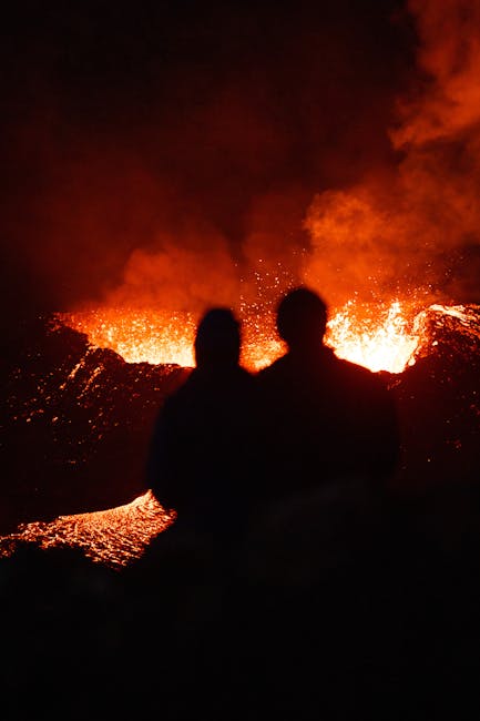 Coppia in silhouette osserva lava incandescente durante eruzione alle Isole Eolie