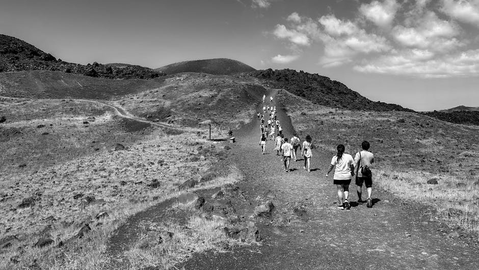 Turyści idą ścieżką po wulkanicznym terenie Wysp Eolskich na Vulcano