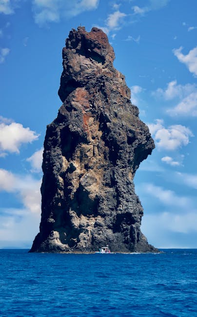 Hoher Felsstapel im Meer bei den Îles Éoliennes, Boot am Fuß