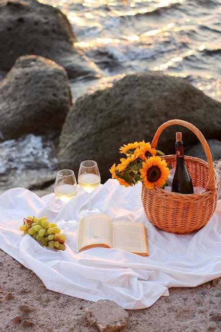 Picnic romantico su scoglio con vino, fiori e mare delle Isole Eolie