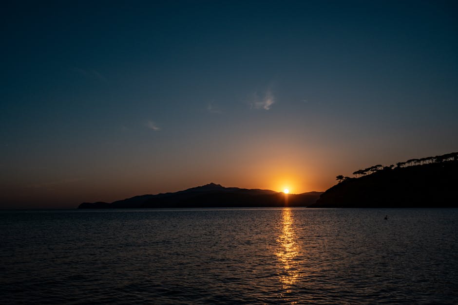 Sunset over Aeolian Islands silhouette with golden reflection on calm sea