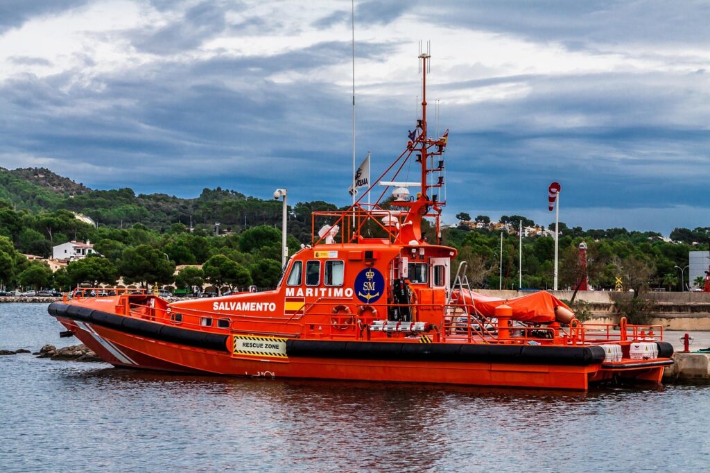 Bright orange maritime rescue boat docked under cloudy skies