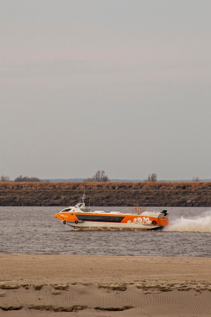 Szybki hydrofoil Alicost przybywający do portu o zachodzie słońca