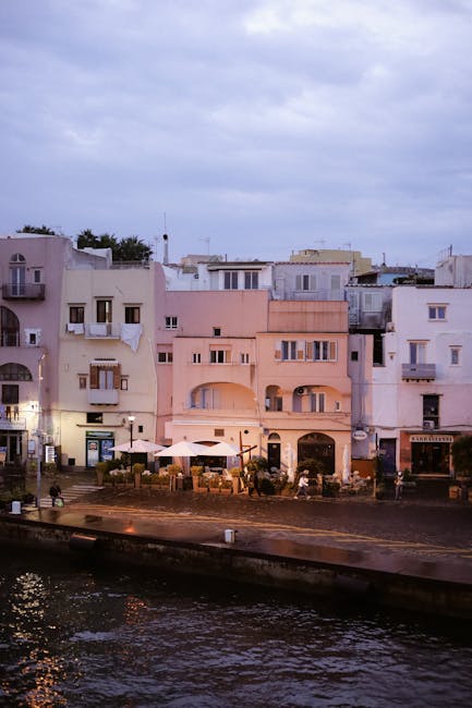 Lungomare con edifici pastello e caffè al porto delle Isole Eolie
