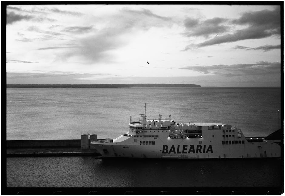 Large Baleària ferry moored at a calm gray harbor