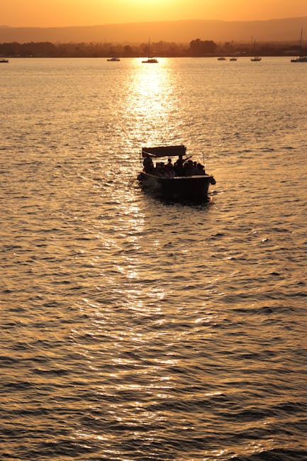 Imbarcazione in controluce su acqua dorata al tramonto nelle Isole Eolie