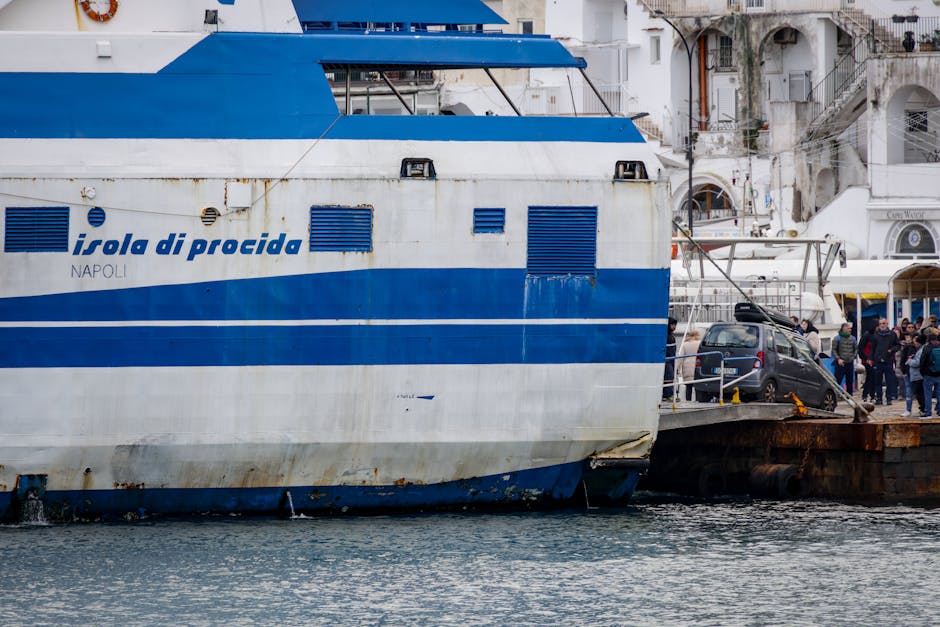 Blue-and-white ferry with car ramp docked at a busy Aeolian Islands port