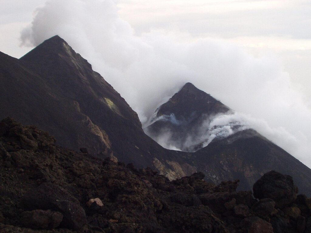 Dikke stoomwolken rond zwarte kraterkegels op Stromboli, Îles Éoliennes