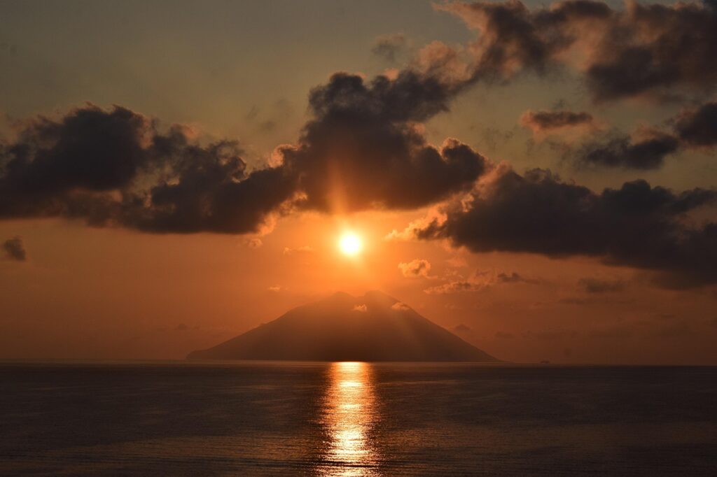 Zonsondergang boven de vulkaan van Stromboli en de zee