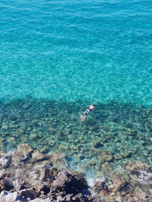 Snorkeler floating over rocky seabed in turquoise water near Îles Éoliennes