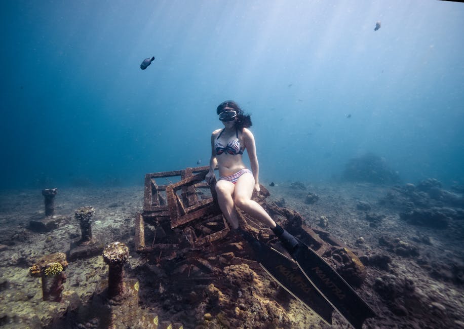Plongeuse en apnée assise sur une épave rouillée, eaux des Îles Éoliennes