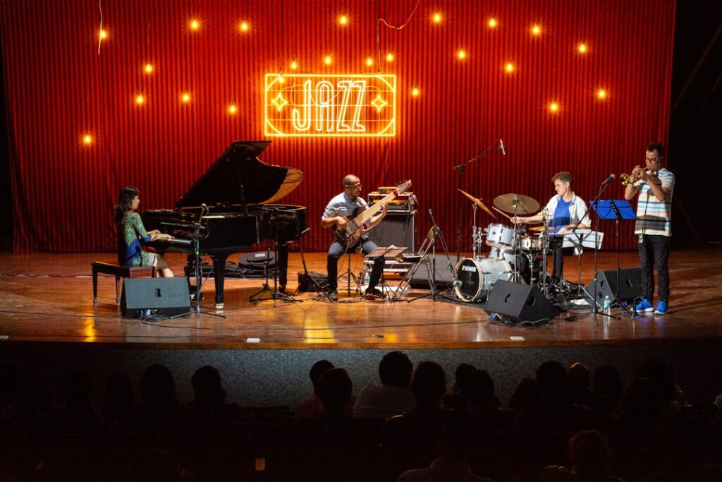 Combo de jazz sur scène sous enseigne néon 'JAZZ' lors d'un festival à Gênes