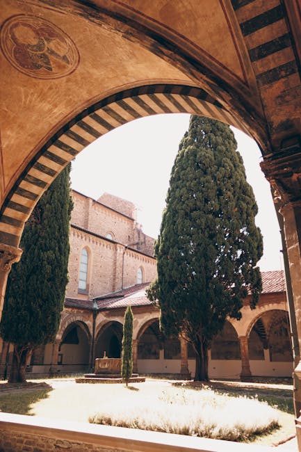 Cloître ombragé avec cyprès et fontaine encadrés par un arc à Gênes