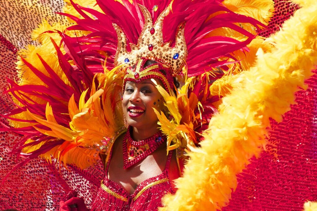 Danseuse costumée en plumes rouges et jaunes, sourire éclatant