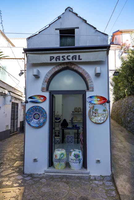 Wąski warsztat ceramiki z napisem PASCAL i wystawionymi talerzami