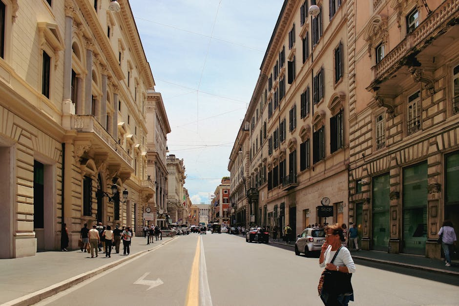 Rue large bordée de palais historiques à Gênes, passants et voitures