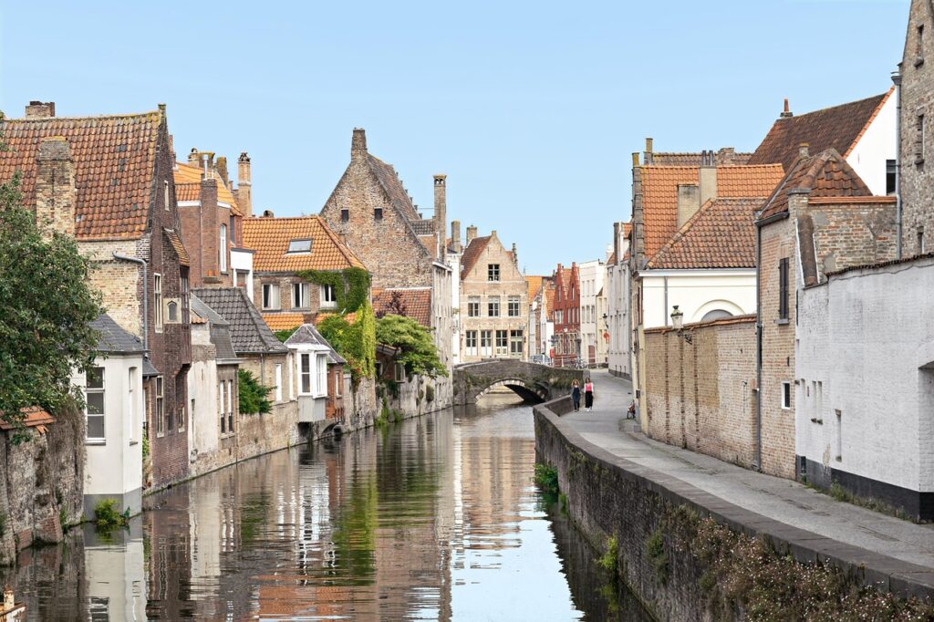 Canal calme bordé de maisons médiévales et d'un petit pont en pierre.
