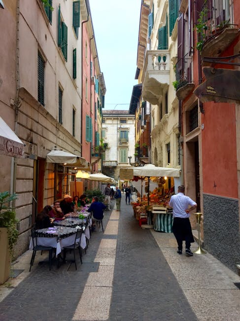 Ruelle étroite avec terrasses et étals de marché à Ravenne.