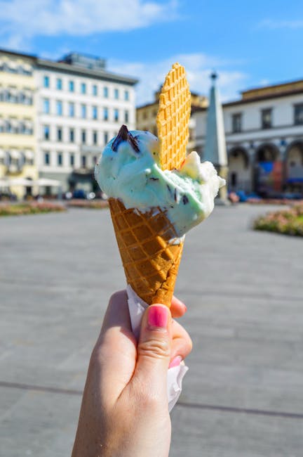 Hand met hoorntje groen ijs en wafel op plein in Ravenna