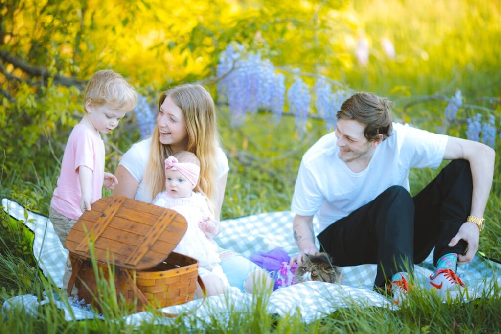 Gezin picknickend op plaid tussen bloemen in een park in Ravenna